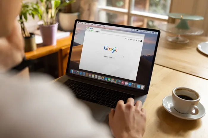 A laptop with a Google search and a cup of coffee next to it
