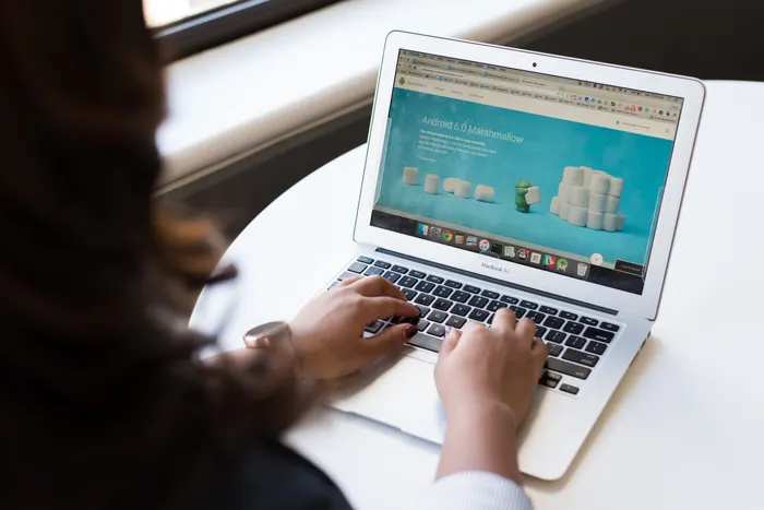 A person typing on a laptop in front of a booking site