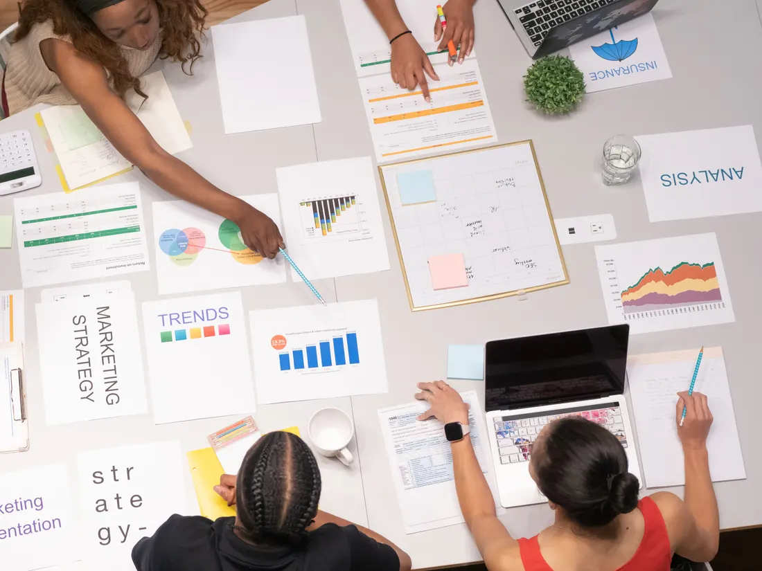 A team leaning over strategy pages and planning a yearly plan